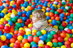 Happy Laughing Kid Boy Having Fun In Ball Pit On Birthday Party